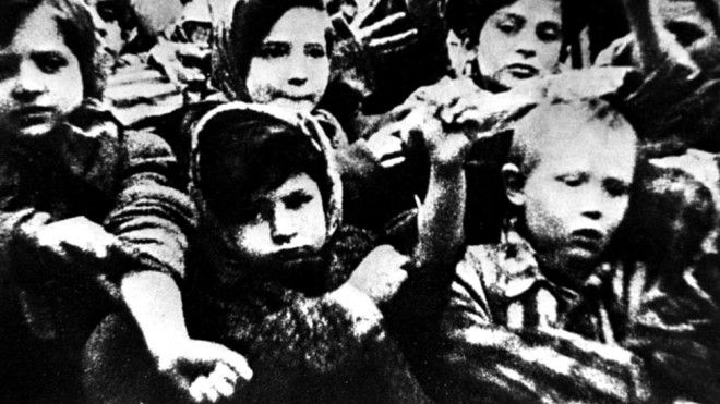 Дети в Освенциме показывают татуировки на руках