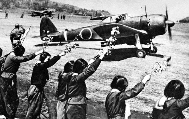 Chiran high school girls are waving farewell with cherry blossom branches to a taking-off kamikaze pilot. The pilot is Second Lieutenant Toshio Anazawa of Army Special Attack Unit (20th Shinbu party). The aircraft, an Army Type 1 fighter 